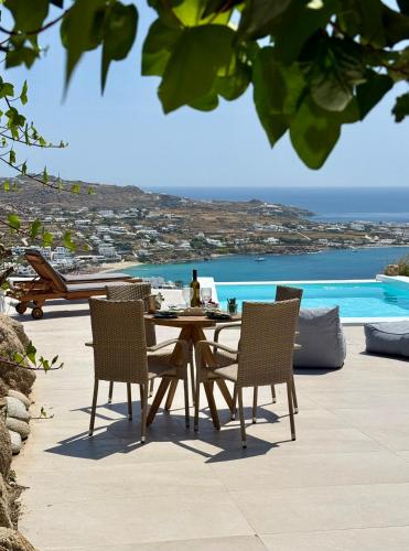 a table and chairs with a view of the ocean at Villa Ocean prince in Mikonos
