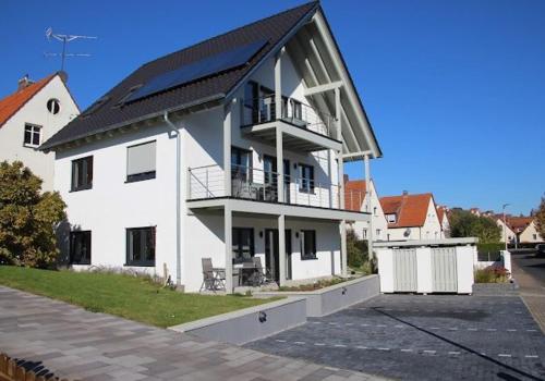 a large white house with a balcony on a street at Ferienwohnungen Derx in Bad Wildungen