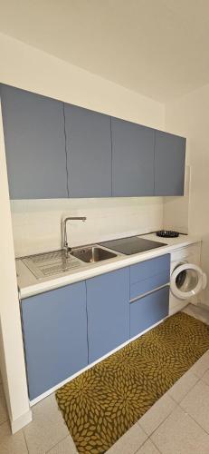 a kitchen with blue cabinets and a sink at Residenze Coda Cavallo in San Teodoro