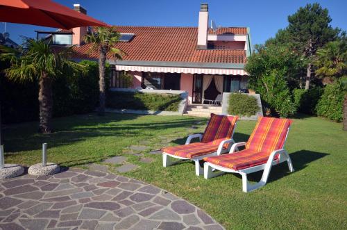 two chairs sitting in the grass in front of a house at Tartaruga in Caleri