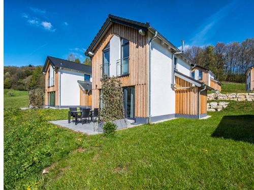 a house with a patio in the yard at Panoramabungalow DHH in Obernsees