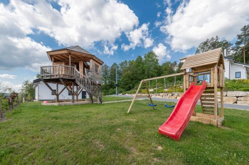 a playground with a slide and a tree house at Panoramabungalow Typ 70 in Truppach
