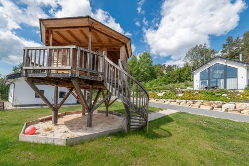 a tree house with a staircase in the grass at Einzelhaus Premium in Truppach