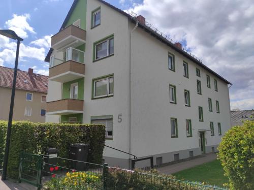 a white building with green windows and a street light at Ferienwohnung Harzoase in Bad Harzburg