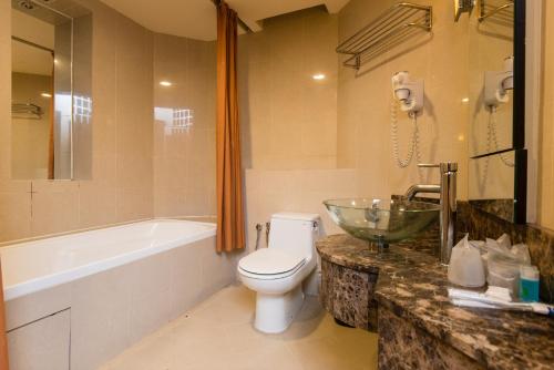 y baño con aseo, bañera y lavamanos. en New Town Resort Suites at Pyramid Tower, en Subang Jaya