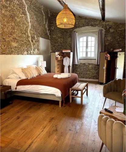 a bedroom with a large bed and a stone wall at Domaine Robert in Rognes