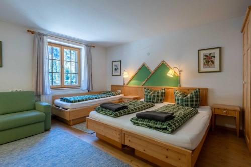 ein Schlafzimmer mit zwei Betten und einem grünen Stuhl in der Unterkunft d'klause in Marul