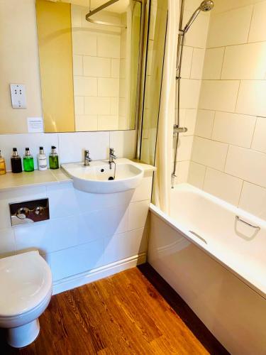 a bathroom with a sink and a toilet and a shower at George Hotel & Granary in Frome