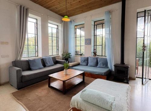 a living room with a couch and a coffee table at tranquil beautiful house כליל השחר- צימרים קסומים במיקום מרגיע למשפחות וזוגות in Clil