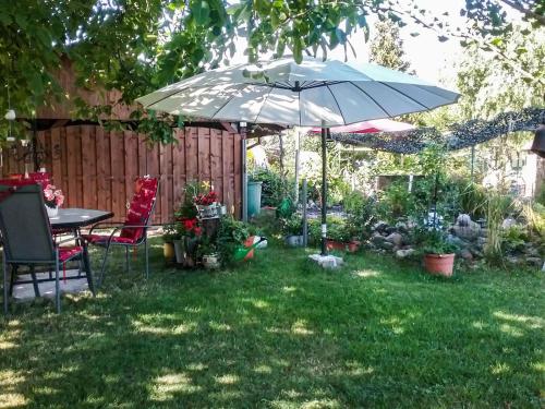 a garden with a table and an umbrella at Gemütliche Ferienwohnung Löbert in Lübbenau