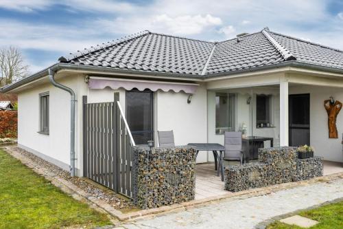 a white house with a fence and a table at Ferienwohnung "OstseeNähe" OFC 34 in Kröpelin