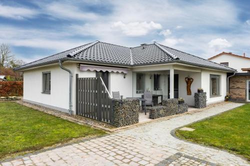 a white house with a black roof at Ferienwohnung "OstseeNähe" OFC 34 in Kröpelin