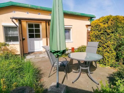 a patio with a table and an umbrella at Ferienwohnungen Sirius in Zinnowitz
