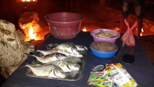 a table with a tray of fish and other foods at Rankaty Residence in Unawatuna
