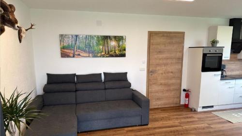 a living room with a couch and a refrigerator at Wild und Wald Ferienwohnung in Steinbach am Attersee