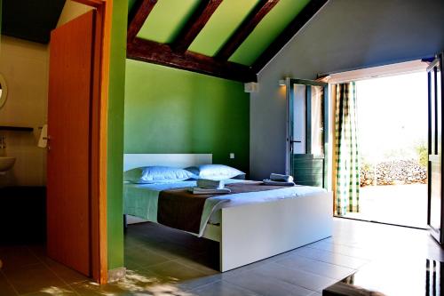 a bedroom with a bed with a green wall at Holiday Home Sweet Dreams in Pučišća