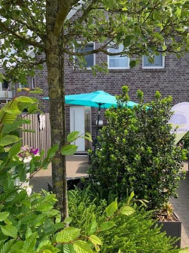a blue umbrella in front of a building at Ferienwohnung Teutoblick Leeden in Tecklenburg