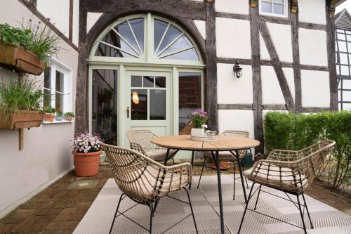 a patio with a table and chairs in front of a building at MispelFachwerkOase in Tecklenburg