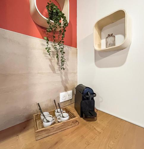 a room with a bunch of pots and a shelf with a plant at T2 lumineux, moderne, calme & central à Montargis in Montargis