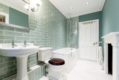 a bathroom with a sink and a toilet and a mirror at Badger Bar in Ambleside