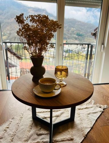 a coffee table with a glass of wine and a vase at Forest home in Konjic