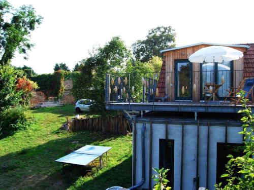 a house with a deck with a table and an umbrella at Ferien am Roten Haus in Buckow