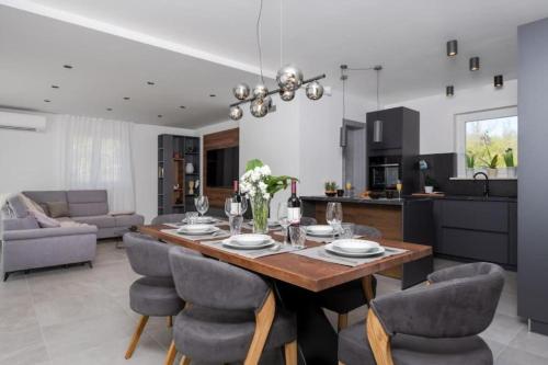 a dining room and living room with a table and chairs at Villa Fortuna - Private Pool and Garden Retreat in Labin