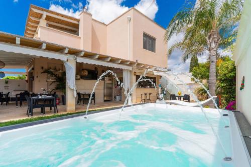 a swimming pool in front of a house at B&B Annita in Porto Cesareo