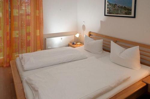 a bed with white sheets and pillows in a bedroom at Residenz Strandkrone 09 in Kühlungsborn