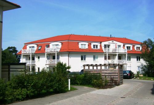 a large white building with a red roof at Residenz Strandkrone 09 in Kühlungsborn
