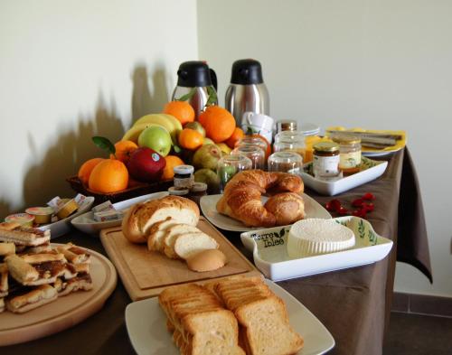 a table topped with different types of bread and fruit at Terre Iblee Resort in Chiaramonte Gulfi