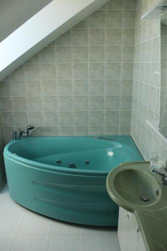 y baño con bañera azul y lavamanos. en Kuru Villa en Kuru