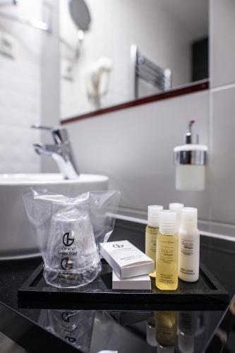 Ein Badezimmer mit zwei Flaschen Feuchtigkeitscreme auf einer schwarzen Ablage. in der Unterkunft Garden Hotel Wellness és Konferencia in Szolnok