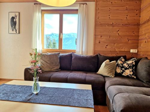 a living room with a brown couch and a table at Ferienwohnung Helene in Sibratsgfäll