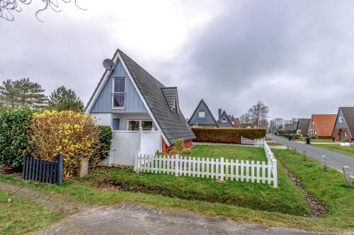 a house with a white picket fence at Ferienhaus Mina in Neuharlingersiel