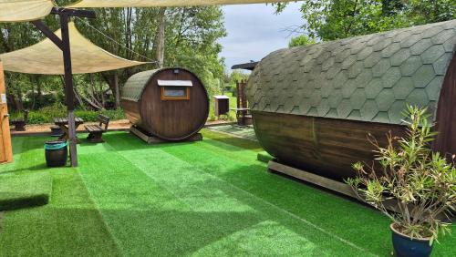a garden with a hobbit house and grass at Mini Hotel Übernachten Im Gurkenfass in Lübbenau