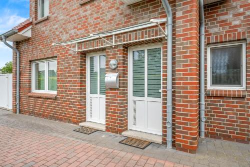 a brick building with two white doors on it at Ferienwohnung Hamtor in Bensersiel