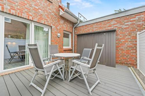 a patio with a table and chairs on a deck at Ferienwohnung Hamtor in Bensersiel