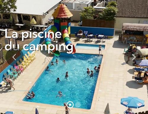 a group of people swimming in a pool at a resort at Tiny House cosy 4 personnes in Vaux-sur-Mer