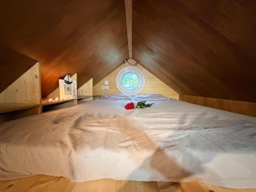 a bedroom with a large white bed with a window at Tiny House cosy 4 personnes in Vaux-sur-Mer