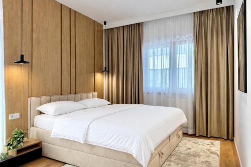 a bedroom with a large white bed and a window at Apartament Stara Fabryka 3 in Włocławek