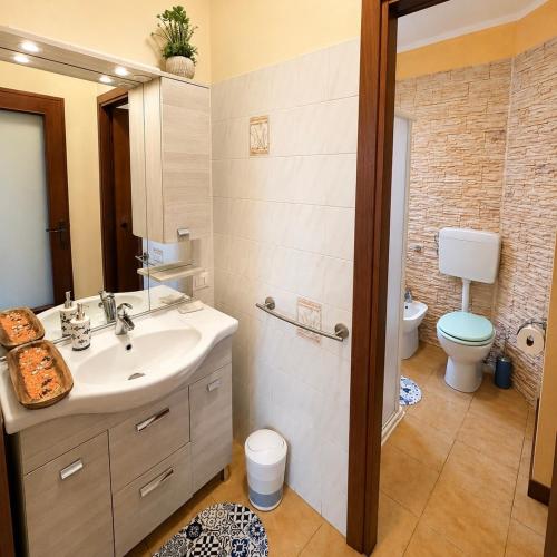 a bathroom with a sink and a toilet at Nido vista Lago Maggiore e isole borromee in Cissano