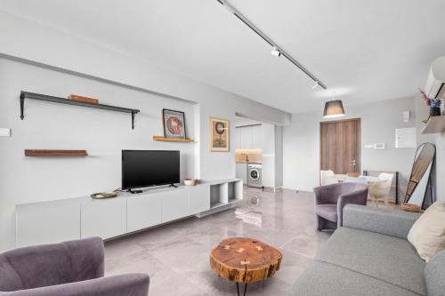 a living room with a couch and a tv and a table at Latitudes 1 Bedroom Apartment in Meneou