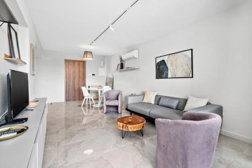 a living room with a couch and a table at Latitudes 1 Bedroom Apartment in Meneou
