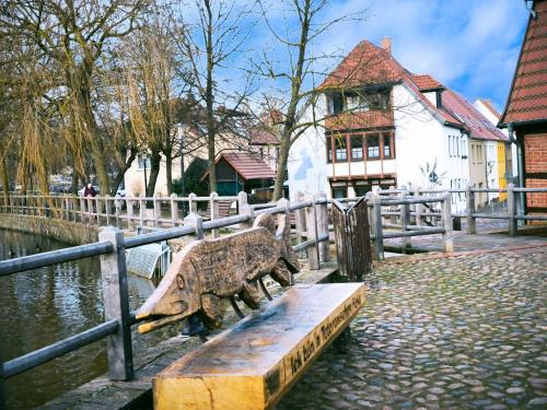 a wooden bench sitting next to a fence at Ferienhaus am Mühlenteich in Teterow