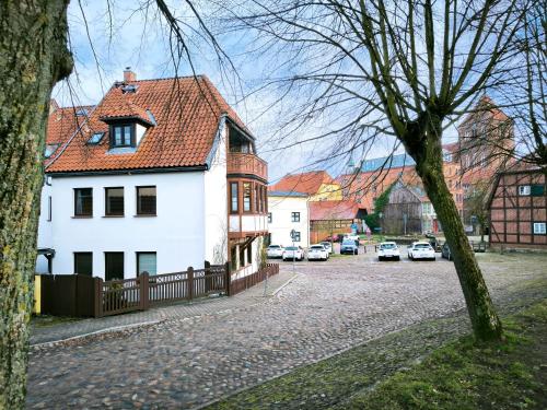 a white house with a red roof on a street at Ferienhaus am Mühlenteich in Teterow