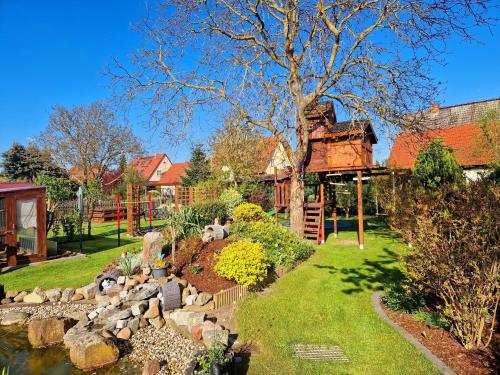 a garden with a pond and a tree house at Ferienwohnung "Christina" in Steinkirchen