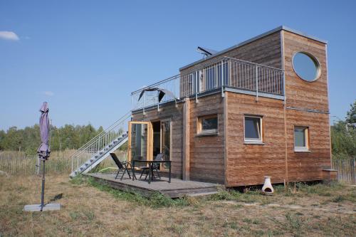 a house with a deck and a staircase on it at Holzhaus am Bergheider See in Buschmühle