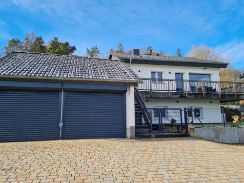 a house with two garage doors in front of it at Haus Atlantis am Edersee in Bringhausen