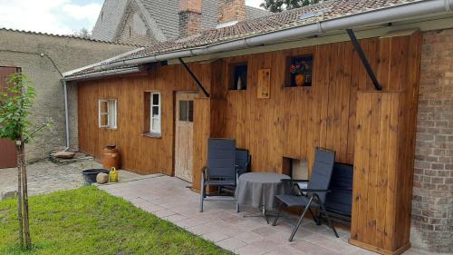 a patio with a table and chairs next to a building at Ferienhaus zur Eiche am Dorfanger in Waldow